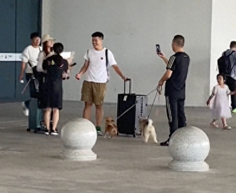 夫妻俩牵着两只狗狗来接儿子和女友,还送上鲜花,温暖又有爱呀!
