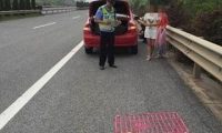 高速公路上爆胎 驾驶员竟把狗装在狗笼里当警示牌